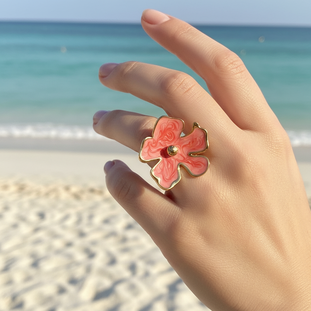 Bague fleur corail portée sur un doigt à la plage