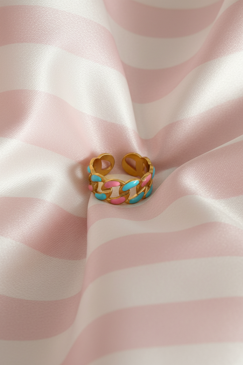 Bague chaîne émaillée vue du dessus sur rayures rose poudre et crème satiné