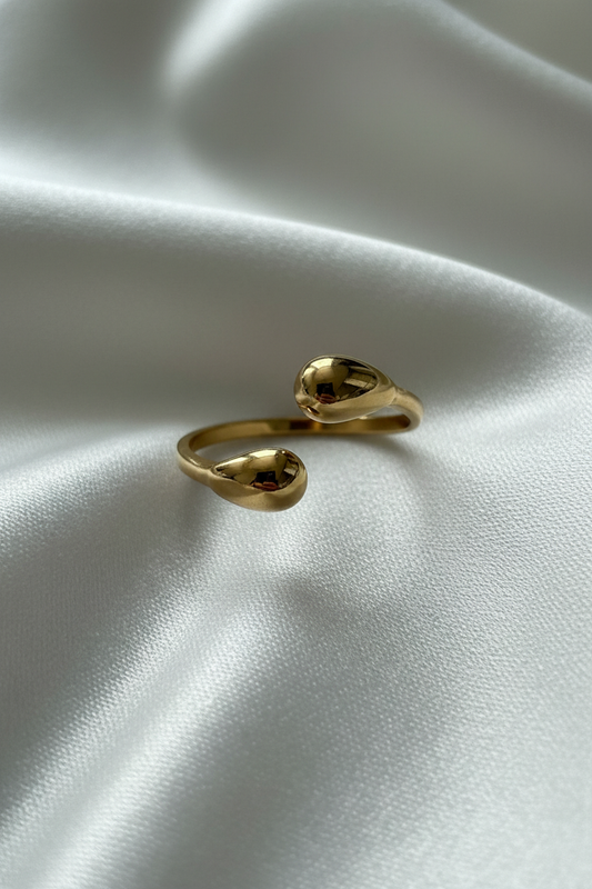 Bague dorée vue dessus fond soie blanc