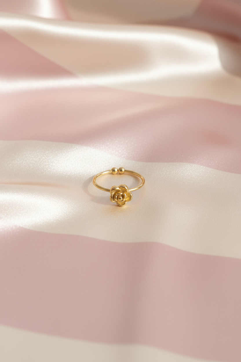 Bague fleur dorée billes vue de face sur rayures rose poudre et crème satiné