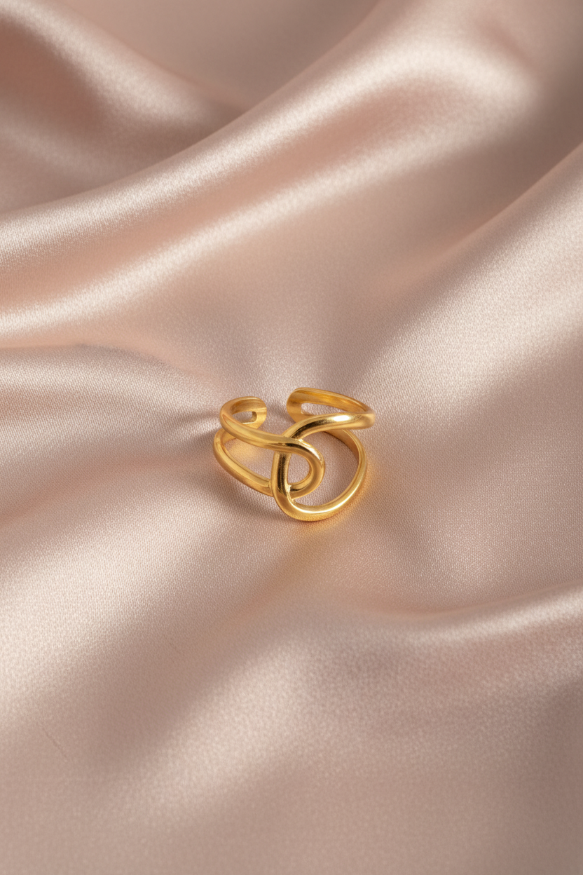 Bague nœud dorée sur satin rose poudre rayé