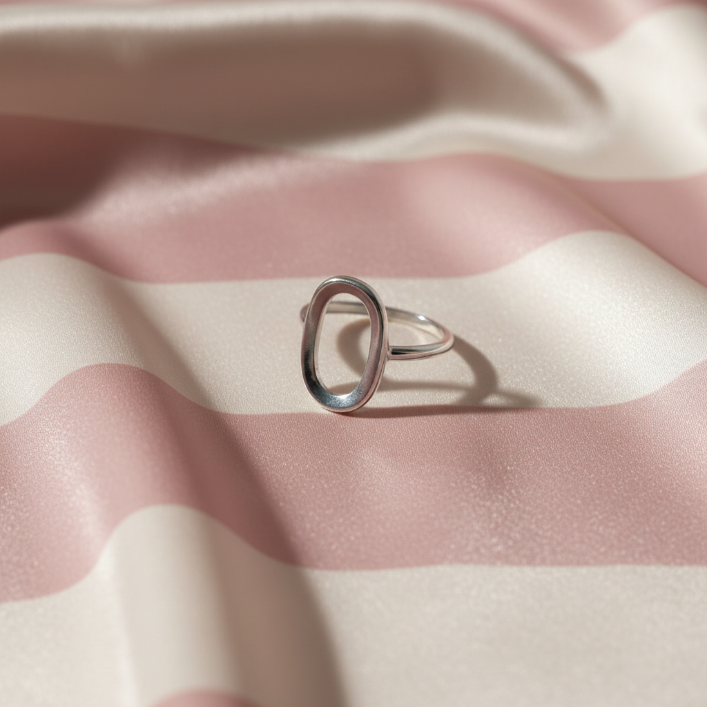 Bague ovale argent – trois-quarts flat lay rayures