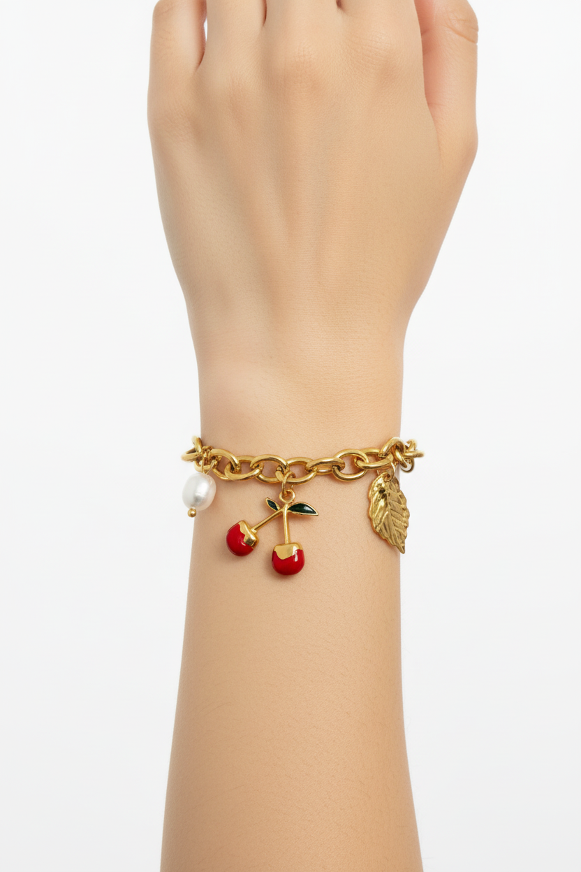 Bracelet chaîne cerises doré sur poignet fond blanc