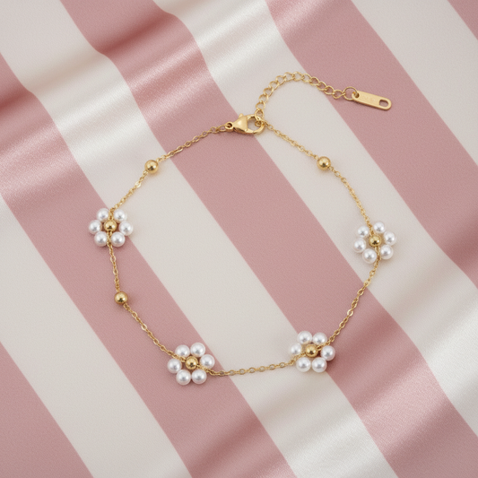 Bracelet fleurs de perles à plat sur fond rayé rose poudré et crème