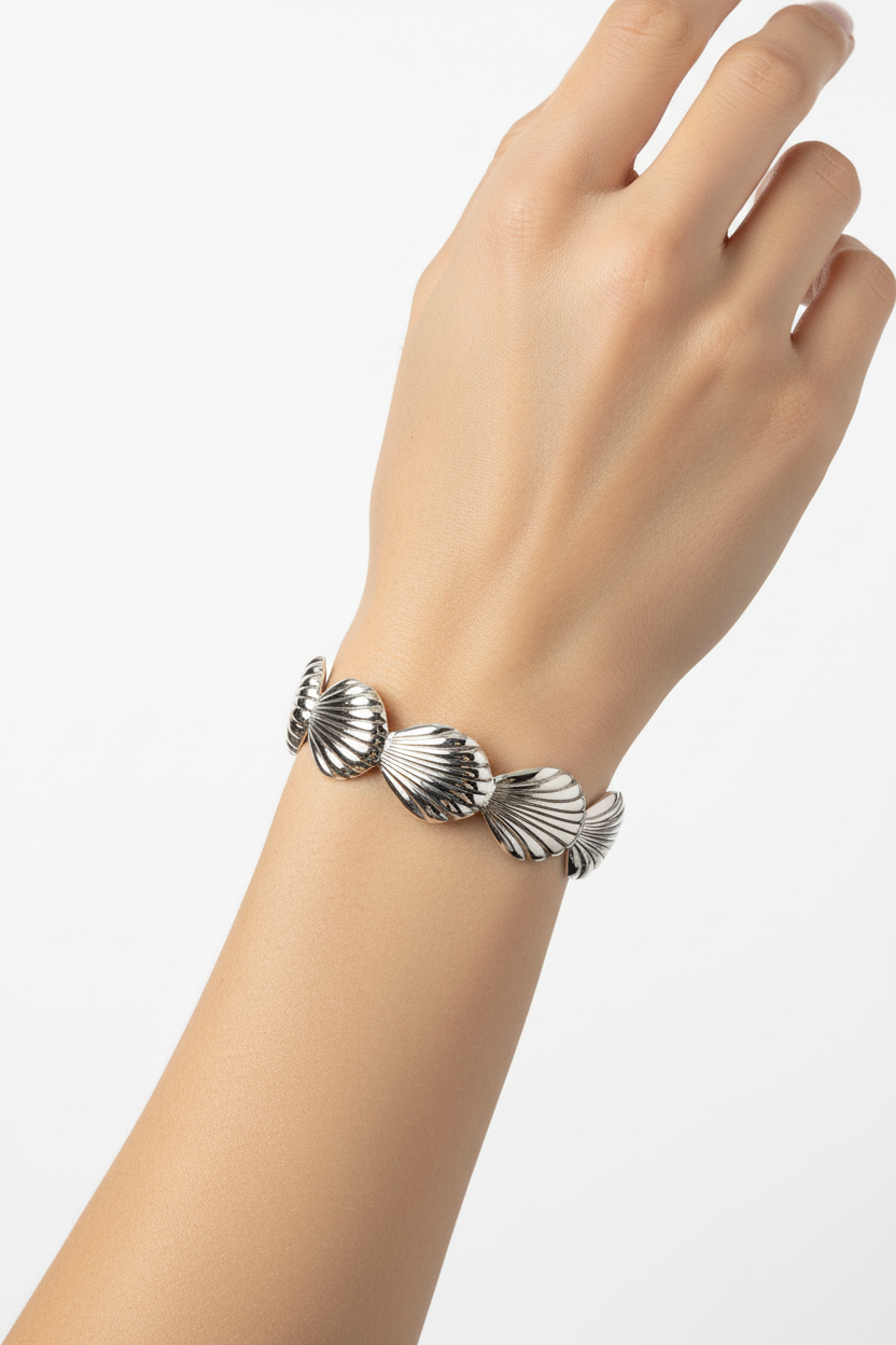 Bracelet manchette coquillages argenté sur poignet fond blanc