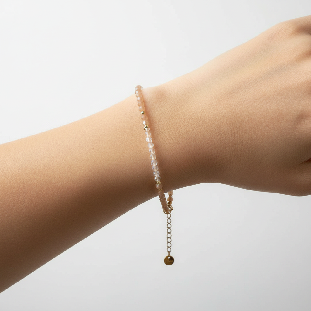 Bracelet perles précieuse pêche/nude sur poignet fond blanc