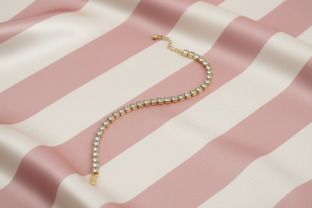 Bracelet tennis à plat sur fond rayé rose poudré et crème