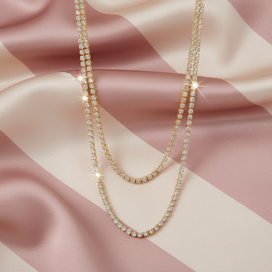 Collier double rang tennis - flat lay - fond rayé rose crème