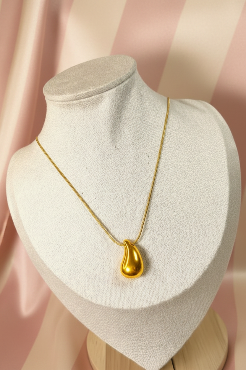 Collier goutte dorée sur buste - fond satiné