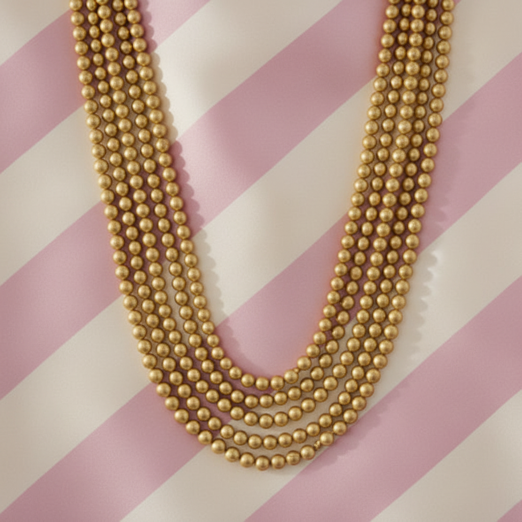 Collier perles porté - fond rayé satiné rose crème